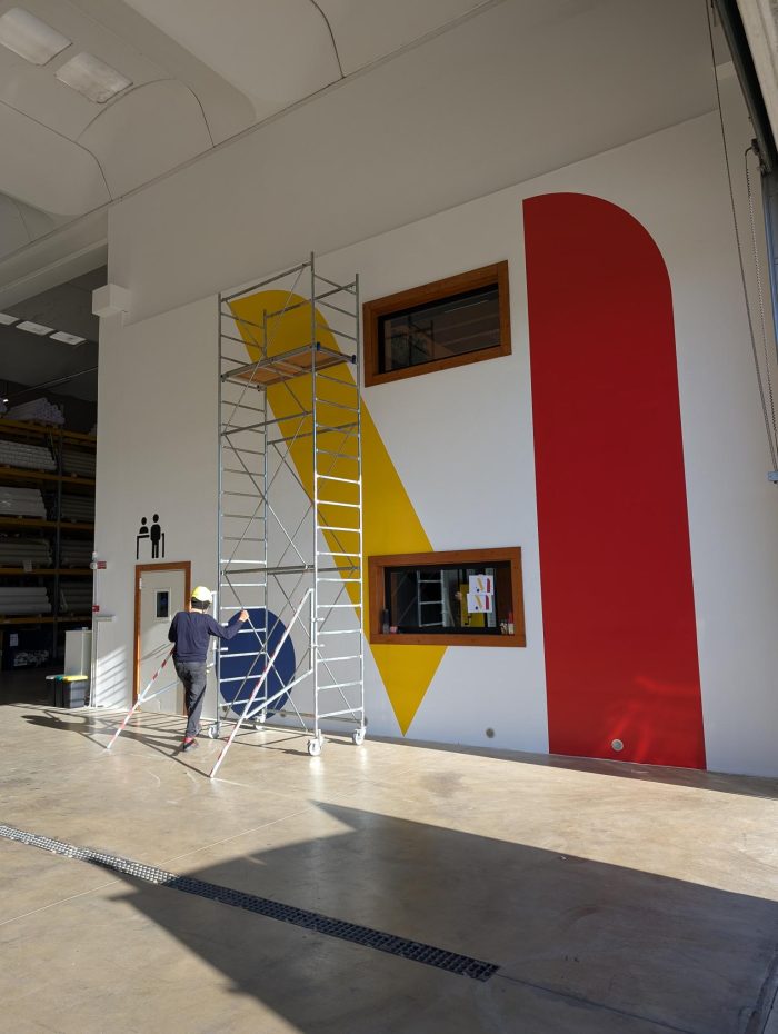 Parete interna decorata con adesivi murali geometrici in grande formato.